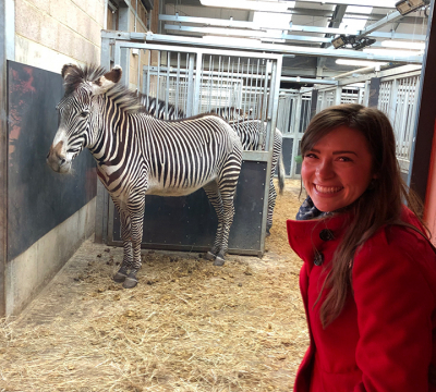 Woman posing with zebra